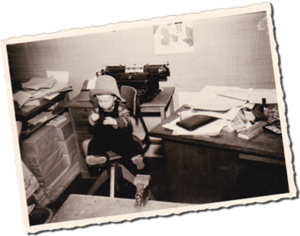 kleiner Junge sitzt im Büro der Druckerei